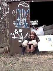15 pictures - Brunette girl pulls down her trousers to pee outside
