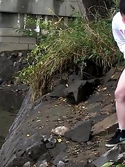 15 pictures - Dark haired girl pisses next to a flowing river