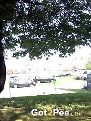 15 pictures - Dark haired woman is filmed pissing by a tree